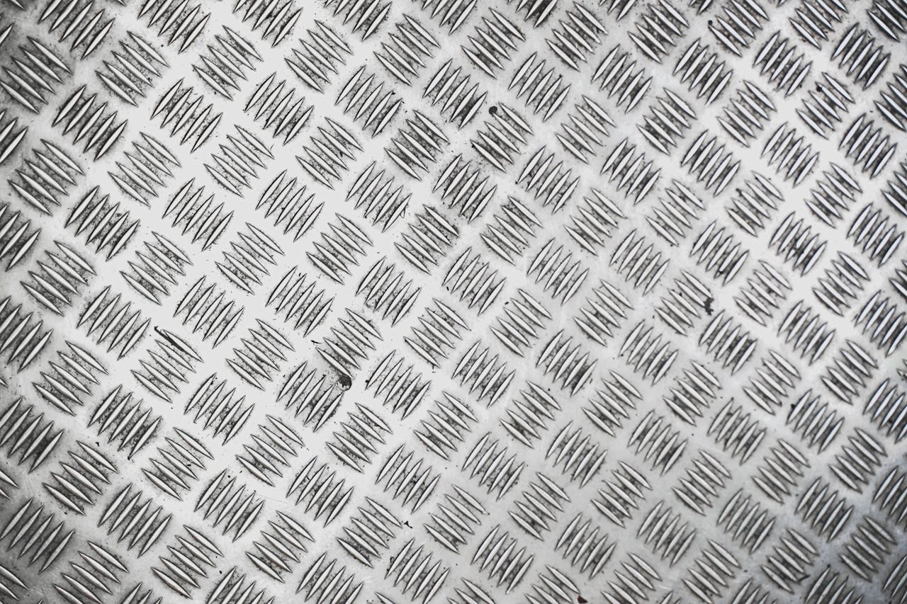 Close-up view of a silver metallic tread plate with a repeating checkered pattern.